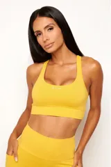 Top deportivo de alto rendimiento con diseño de espalda nadador, confeccionado en tejido técnico con protección UV50+. Presenta un bolsillo interno en el forro frontal y detalles reflectivos.