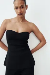 Top negro de punto con escote corazón, estilo palabra de honor y bajo con línea evasé.