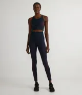 Legging deportiva de tiro alto confeccionada en tejido de poliamida sin costuras. Presenta un diseño ajustado al cuerpo con detalles geométricos contrastantes en la parte inferior de las piernas.