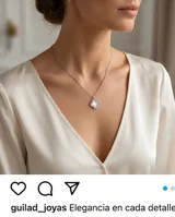 Collar de acero con dije en forma de flor de cuatro pétalos, con centro de nácar y borde pavé de circonias.
