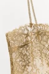 Top de tirantes finos con escote recto, confeccionado en tejido de encaje semitransparente con hilo metalizado dorado.