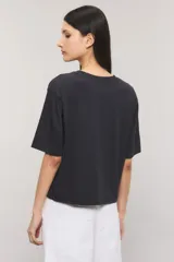 Remera Kosiuko de algodón color blanco, de corte regular y mangas cortas hasta el codo. Cuenta con un diseño estampado en el frente con la leyenda "Messy Chic Kosiuko St. Tropez".