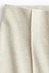 Pantalón de corte holgado confeccionado en punto fino de mezcla de algodón, con tiro alto y pliegues verticales cosidos en el frente.