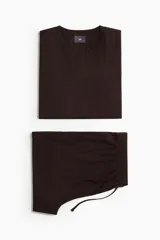 Conjunto de pijama de dos piezas color marrón oscuro, compuesto por una remera de manga corta con cuello redondo y un short con cintura elástica ajustable mediante cordón y bolsillos laterales.