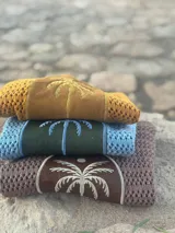 Saco de tejido abierto con aplique central de cuero natural bordado con diseño de palmera.