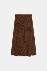 Falda midi de corte evasé con estampado de lunares, forro interior corto y detalle de lazo lateral con abalorios. Cuenta con cierre de cremallera oculta en la costura.