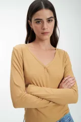 Remera azul de punto canalé, de manga larga y escote en V con botones.