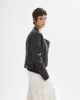 Campera negra de cuero sintético, con cierre lateral y detalles acolchados en hombros y mangas.