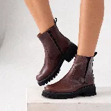 Bota corta estilo chelsea de cuero vacuno negro con acabado desgastado en tono marrón en la puntera y laterales. Presenta elástico lateral, cierre interno y suela de goma tipo track con plataforma.