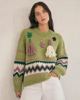 Sweater de lana merino color beige, con diseño tejido de punto jacquard estilo nórdico en tonos marrón, negro, blanco y lila en el pecho y las mangas. Cuenta con cuello redondo, puños y dobladillo acanalados.