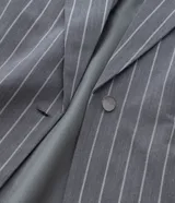 Blazer gris con riscas de giz, de corte sastre, con cuello con solapa y bolsillos simulados.