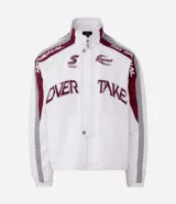 Campera deportiva de microfibra de poliamida blanca, con cuello alto, mangas largas, cierre frontal y bolsillos. Presenta paneles laterales en bordó y gris, y detalles de estampado con inscripciones alusivas al automovilismo.