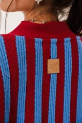Saco oversize tejido con diseño de rayas verticales en colores rojo y azul. Presenta escote en V, cierre frontal con botones y puños y ruedo acanalados.