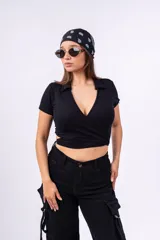 Top negro de punto canalé con cuello tipo chomba, corte cropped y diseño cruzado con abertura en la cintura.