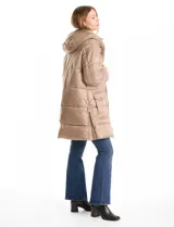 Campera puffer larga de color marrón oscuro, con diseño capitoneado de costuras horizontales. Presenta un sistema de cierre doble con pechera interna fija con cierre y cuello alto, y cierre frontal exterior con botones a presión. Incluye bolsillos frontales amplios, capucha fija y cierres laterales en el ruedo para mayor movilidad.