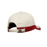 Gorro con visera Quiksilver modelo Decades, de color blanco con detalles en rojo, incluyendo visera y apliques traseros en contraste. Cuenta con el nombre y logo de la marca bordados en la parte frontal con tipografía estilo universitario.