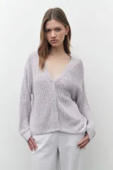 Cardigan lila de tejido de punto con escote en V y cierre con botones. Mangas largas y corte holgado.