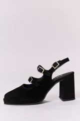 Zapatos de tacón tipo Mary Jane en gamuza color marrón, con doble tira con hebillas metálicas doradas sobre el empeine, punta cuadrada y taco bloque alto.