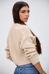 Sweater de punto con diseño de trenzas, color beige, de corte cropped y cuello redondo.
