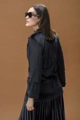 Blazer de terciopelo negro con solapas clásicas, cierre frontal con un botón y bolsillos laterales con solapa.