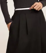 Pollera midi evasé color negro confeccionada en tricolina de algodón sostenible con elástico en la cintura y textura empapelada.