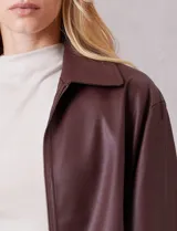 Campera de eco cuero color bordó, con cuello camisero, cierre frontal metálico y bolsillos laterales. Presenta un diseño de corte recto y forro interno a tono.