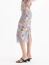 Pollera midi gris con estampado floral y detalles artísticos, de corte tubo y tiro medio, con terminación de encaje en el ruedo.