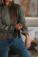 Remera de manga larga color verde oliva, con cuello redondo y tejido acanalado.