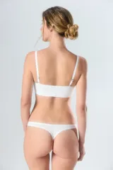 Top deportivo blanco con tirantes ajustables y diseño sin costuras.