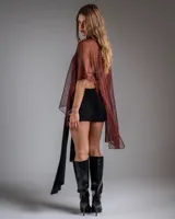 Poncho de tejido abierto con acabado brillante y diseño asimétrico de un solo hombro.