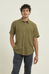 Camisa sport de manga corta, confeccionada en una mezcla de lino y algodón. Presenta cuello clásico, cierre frontal con botones de coco y un bolsillo aplicado en el pecho.