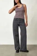 Jean de corte wide leg y tiro medio, color gris oscuro, con diseño de cinco bolsillos y cierre frontal con botón y cremallera.