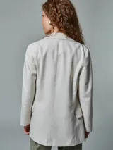 Blazer recto color crudo, de lino, con solapas de muesca, cierre cruzado con doble botonadura, mangas largas y bolsillos con solapa.