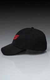 Gorra de gabardina negra con visera curva y bordado frontal en hilo rojo con la palabra "Ravers" en tipografía cursiva. Posee ajuste trasero de velcro.