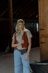 Chaleco de cuero marrón con detalle de tachas en el contorno.