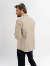 Camisa de manga larga color azul marino, confeccionada en algodón, con cuello abotonado y cierre frontal de botones.