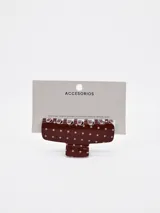 Pinza para el pelo color marrón con estampado de lunares blancos.