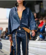 Campera de cuero azul con interior marrón, corte recto, cuello camisero y cierre con botones.