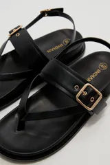 Sandalias negras de eco cuero estilo chunky, con diseño de tiras cruzadas y hebilla metálica dorada en la parte superior. Cuenta con tira ajustable en el talón.