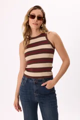 Top tejido de punto sin mangas con cuello redondo, diseño ajustado al cuerpo y estampado de rayas horizontales en blanco, negro y detalles en rojo.