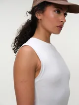 Musculosa básica blanca de corte ajustado y cuello redondo al cuerpo, confeccionada en algodón elastizado.