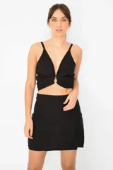 Minifalda negra de corte recto y tiro alto con cierre invisible.