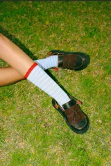 Mocasines de cuero en color marrón oscuro con detalles de flecos y tira con hebilla en el empeine.