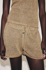 Shorts de tejido rústico en tonos tierra con tiro medio, cintura elástica con cordón de ajuste y detalles de ribetes a tono en los bajos.