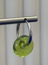 Aros tipo argolla con dije colgante en forma de dona de vidrio color verde lima.