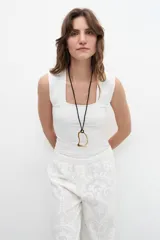 Top sin mangas de color blanco, con escote cuadrado y ajuste al cuerpo.