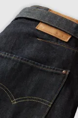 Pantalón capri de denim negro con corte amplio, tiro alto y cinturón de tela con hebilla metálica.