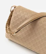 Cartera tipo shoulder bag de tamaño mediano, confeccionada en material sintético efecto gamuza color beige. Presenta un diseño estructurado con textura geométrica de triángulos en relieve, tapa frontal con cierre y correa de cadena metálica dorada con apoyo para el hombro.