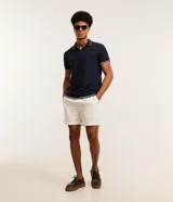 Remera polo blanca de viscosa texturizada con rayas, cuello y puños de mangas cortas en ribana con detalles contrastantes en negro.