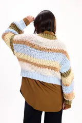 Buzo de punto grueso con diseño de rayas horizontales en tonos crema, marrón, celeste y verde oliva. Presenta cuello redondo, mangas largas y un corte holgado con terminaciones acanaladas.